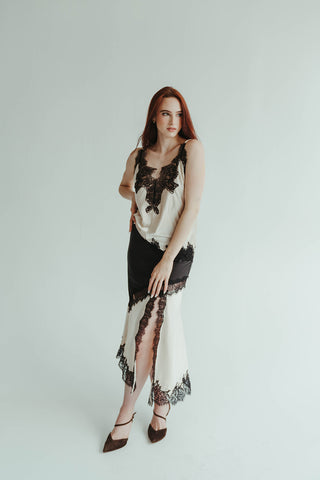 Woman wearing a black and white lace dress on a plain background