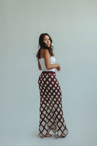 Woman wearing a patterned skirt and white top against a plain background
