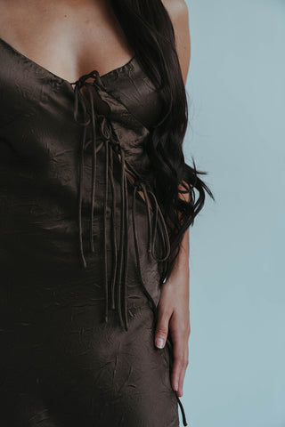 Brown dress with lace-up back on a plain background