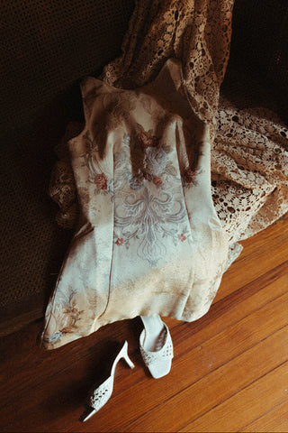 Vintage lace garment and high-heeled shoes on a wooden floor