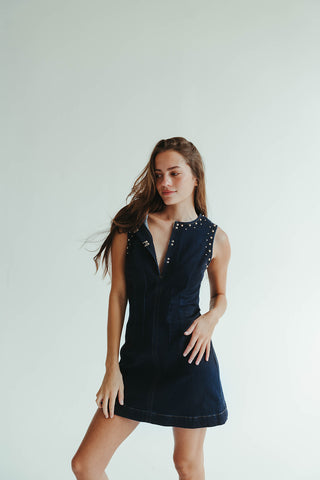 Woman wearing a navy dress with a white background