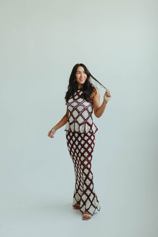 Woman wearing a patterned dress against a plain background